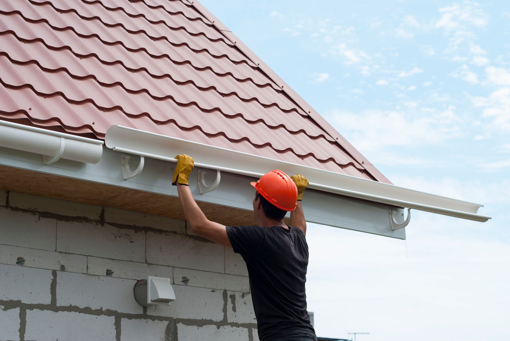 Man installing gutters on home